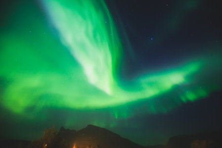 Beautiful picture of massive multicolored green vibrant Aurora Borealis, Aurora Polaris, also know as Northern Lights in the night sky over Norway, Scandinaviaの写真素材