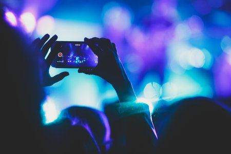 A crowded concert hall with stage stage lights, rock show performance, with people silhouettes during live music show performance with crowd of audienceの写真素材