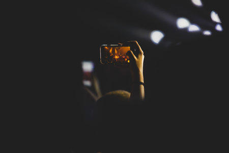 A crowded concert hall with stage stage lights, rock show performance, with people silhouettes during live music show performance with crowd of audienceの写真素材