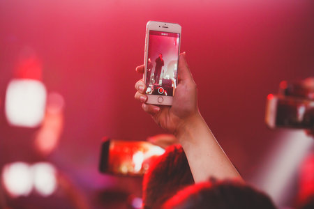 A crowded concert hall with stage stage lights, rock show performance, with people silhouettes during live music show performance with crowd of audienceの写真素材