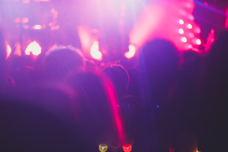 A crowded concert hall with stage stage lights, rock show performance, with people silhouettes during live music show performance with crowd of audienceの写真素材
