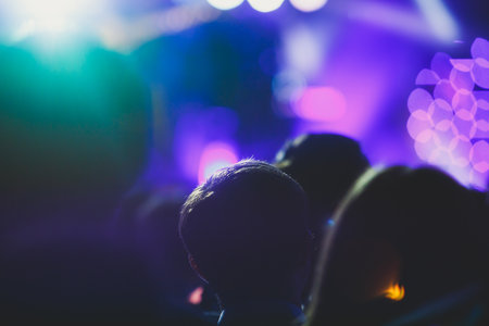 A crowded concert hall with stage stage lights, rock show performance, with people silhouettes during live music show performance with crowd of audienceの写真素材
