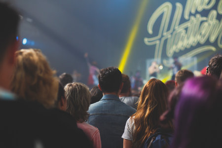 A crowded concert hall with stage stage lights, rock show performance, with people silhouettes during live music show performance with crowd of audienceの写真素材