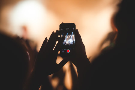 A crowded concert hall with stage stage lights, rock show performance, with people silhouetteの写真素材