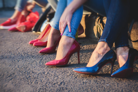 Row line of a legs on high heels in jeans pants during bachelorette party or a birthday, a group of bridesmaids having funの写真素材