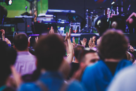 A crowded concert hall with stage stage lights, rock show performance, with people silhouettes during live music show performance with crowd of audienceの写真素材