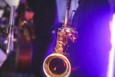 Concert view of a saxophone player with vocalist and musical jazz band in the backgroundの写真素材