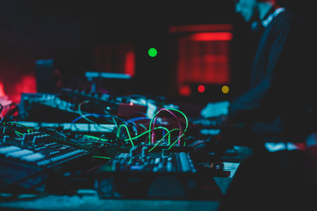View of Dj mixer and vinyl plate with headphones on a table with DJ playing and mixes the track in the background, during night techno party in the nightclubの写真素材