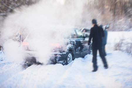 Process of taking out suv car stuck in snow, men digging and pushing the car out of snow, concept of winter problems with carの写真素材