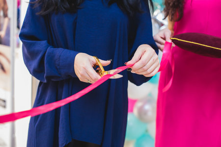 Process of cutting the red ribbon during the grand opening of the new shopping center mall building,...