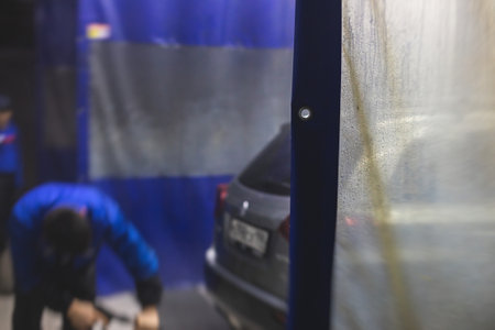 Process of washing the silver gray car in the carwash, concept of manual car wash with pressurized...