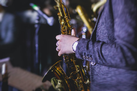 Concert view of a female saxophonist, professional saxophone player with vocalist and musical during jazz band performingの写真素材