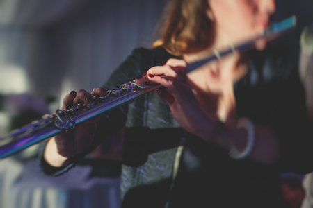 Concert view of a flutist flute player with musical jazz band and audience in the backgroundの写真素材