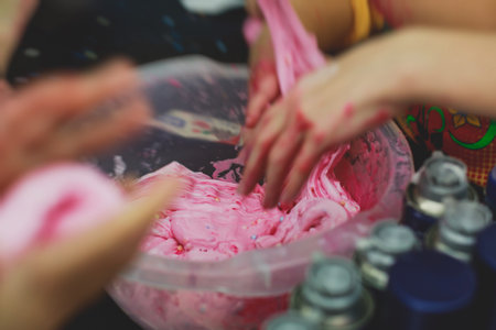 Group of kids making a multicolored slime, pink, blue and white slime toy on kids birthday party, kid playing with slime, homemade slimeの写真素材