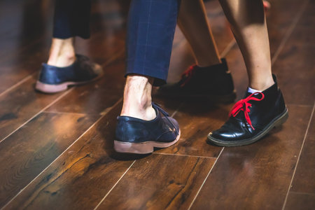 Dancing shoes of young couple dance retro jazz swing dances on a ballroom club wooden floor, close up view of shoes, female and male, dance lessonsの写真素材