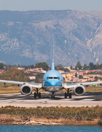 View of modern passenger plane aircraft on an runway airfield ready to take off, airstrip with commercial airplane before take off or after landing, airliner with mountains in summer dayの写真素材