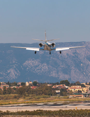 View of modern private reactive plane aircraft in flight, business airliner jet airplane before in the air with mountains in the background in a summer sunny day, light corporate jet viewの写真素材