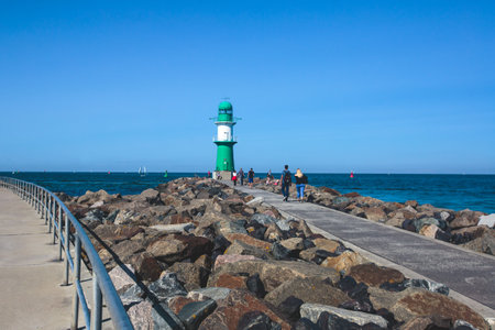 Beautiful summer vibrant view of Warnemunde, Rostock, Germany, popular german seaside resort, with beach, seashore and lighthouseの写真素材