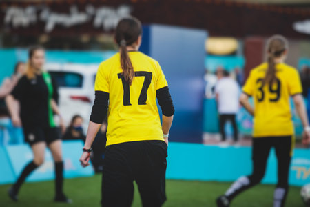 Female football street match outdoor game on an artificial astroturf lawn, girls play soccer game on a pitch field, young women participate in football competition on a stadium with green grassの写真素材