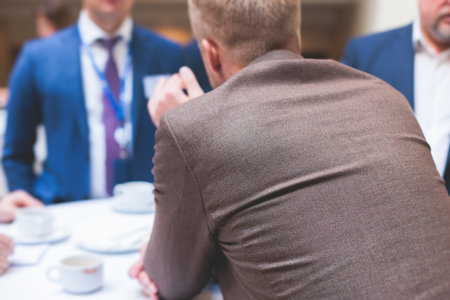 Group of men in business suits talking and discussing during coffee break at conference, politicians and entrepreneurs networking and negotiate, businessmen have dialog conversation on a forumの写真素材