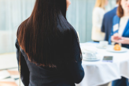 Group of women in business suits talking and discussing during coffee break at conference, female politicians and entrepreneurs networking and negotiate, businesswomen dialog conversation on a forumの写真素材