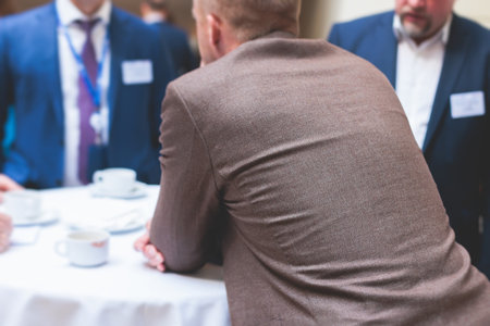 Group of men in business suits talking and discussing during coffee break at conference, politicians and entrepreneurs networking and negotiate, businessmen have dialog conversation on a forumの写真素材