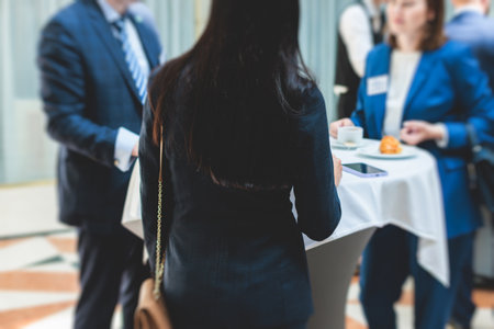 Group of women in business suits talking and discussing during coffee break at conference, female politicians and entrepreneurs networking and negotiate, businesswomen dialog conversation on a forumの写真素材