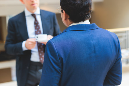 Group of men in business suits talking and discussing during coffee break at conference, politicians and entrepreneurs networking and negotiate, businessmen have dialog conversation on a forumの写真素材