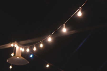 Crowded vintage sale market with decorations, illumination and hanging toys, balloons, garlands and festoons, Xmas fair interior, retail sale kiosk and store with an illumination, street marketの写真素材