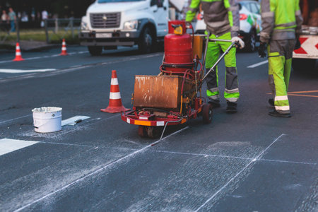 Process of making new road surface markings with a line striping machine, workers improve city...
