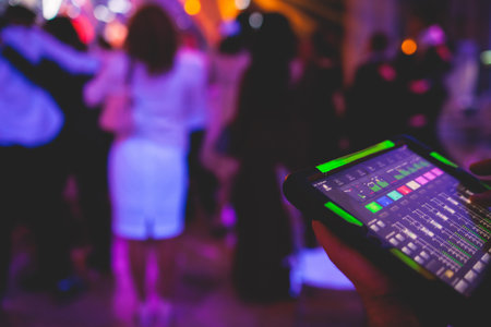 View of lighting technician with tablet, operator controlling sound and light during live event concert on stage show broadcast, technician with professional equipment, working on a mixing consoleの写真素材