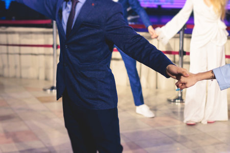 High school graduates dancing Waltz and classical ball dance in dresses and suits on a school prom...