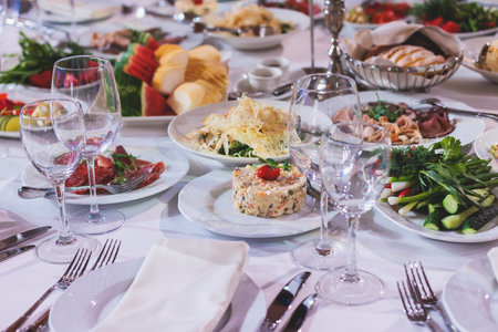 Catering table, beautifully decorated banquet with variety of with different food snacks appetizers...