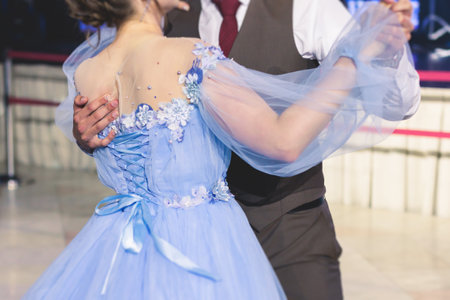 High school graduates dancing Waltz and classical ball dance in dresses and suits on a school prom graduation, classical ballroom dancers dancing, Waltz, couples quadrille and polonaiseの写真素材