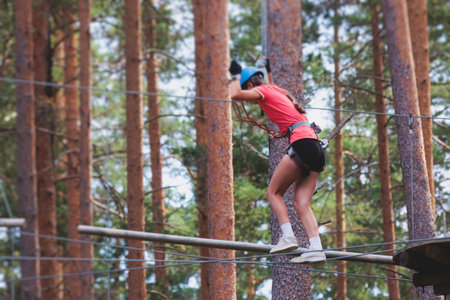 View of high ropes course, process of climbing in amusement acitivity rope park, passing obstacles...