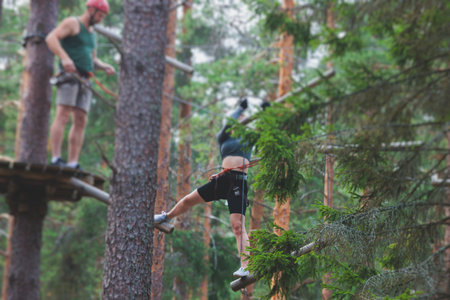 View of high ropes course, process of climbing in amusement acitivity rope park, passing obstacles...