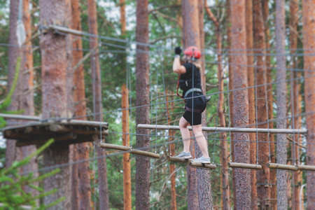 View of high ropes course, process of climbing in amusement acitivity rope park, passing obstacles...
