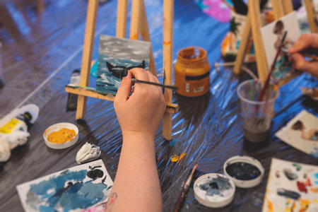 Process of drawing, group class of talented students with painting easels and canvases during lesson of watercolor painting outdoors, drawing class for adult artists in art schoolの写真素材