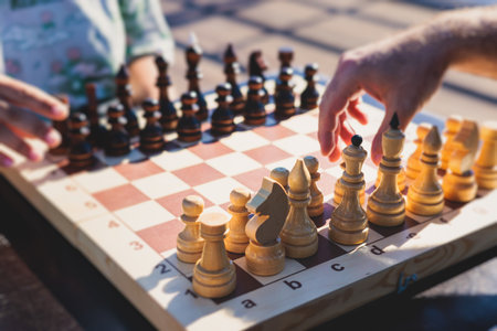 Chess tournament, kids and adults participate in chess match game outdoors in a summer sunny day,...