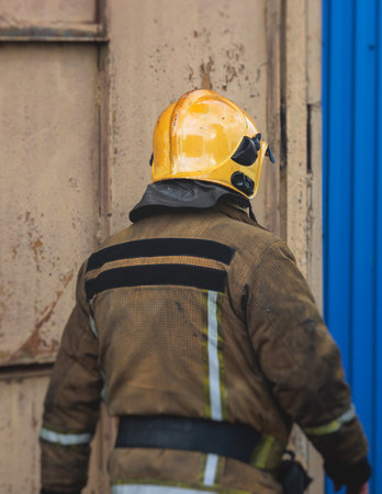 Group of fire men in protective uniform during fire fighting operation in the city streets,...