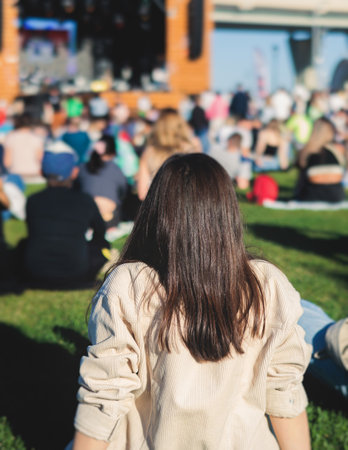 Crowded open air festival concert with scene lights with musicians band on stage at the venue, rock show performance, with concert-goers attendees, audience on dance floor during summer festivalの写真素材