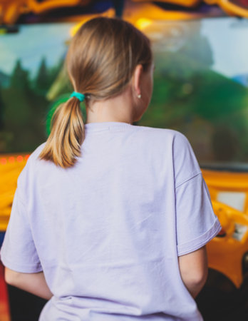 Kids play slot machine at amusement theme park, children play arcade gaming machine, racing and shooting game at the fair, teenagers having fun playing simulator video gamesの写真素材