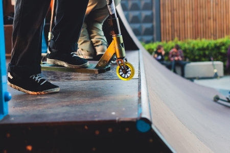 Skate park with kids on a kick scooter doing tricks and stunts, boys in a skate park riding bmx bike...