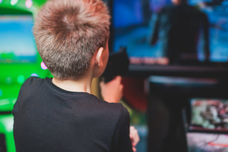 Kids play slot machine at amusement theme park, children play arcade gaming machine, racing and...