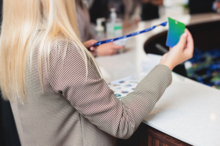 Process of checking in on a conference congress forum event, registration desk table, visitors and attendees receiving a name badge and entrance wristband bracelet and register electronic ticketの写真素材