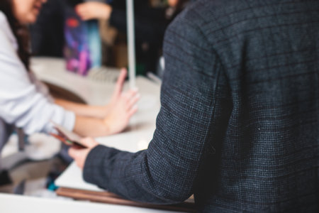 Process of checking in on a conference congress forum event, registration desk table, visitors and attendees receiving a name badge and entrance wristband bracelet and register electronic ticketの写真素材