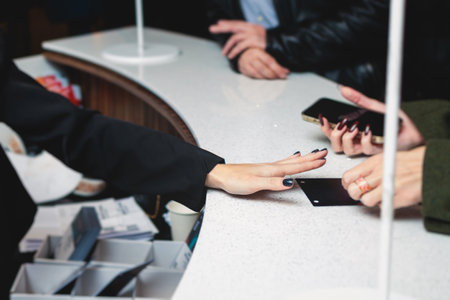 Process of checking in on a conference congress forum event, registration desk table, visitors and attendees receiving a name badge and entrance wristband bracelet and register electronic ticketの写真素材