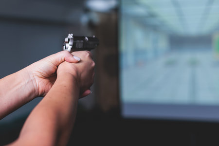 Process of shooting target at the shooting rifle range, women practicing with hand gun pistol at...