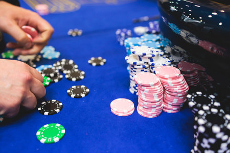 Vibrant casino table with roulette in motion, with casino chips, tokens, the hand of croupier,...