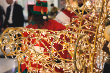 Kids waiting to meet and see Santa Claus, children asking Santa Claus for a gift on Christmas fair market in a shopping mall trade center, boys and girls visit Santa and receive gifts and presentsの写真素材